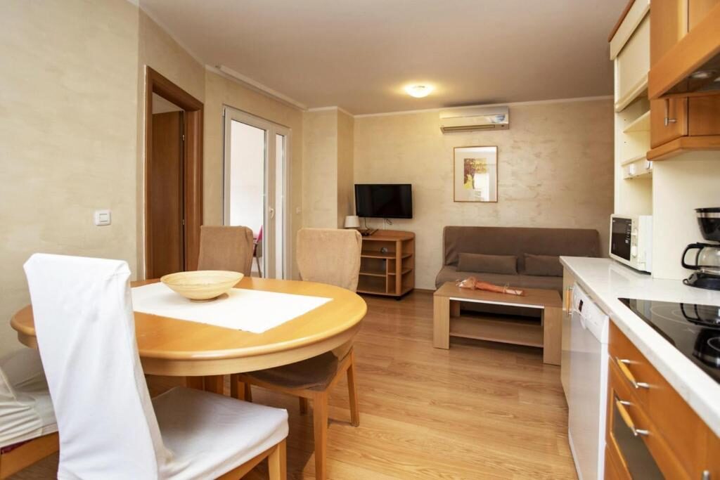 Dnevni boravak Comfort apartmana s okruglim drvenim stolom i kuhinjom, Apartments Ulika Rovinj