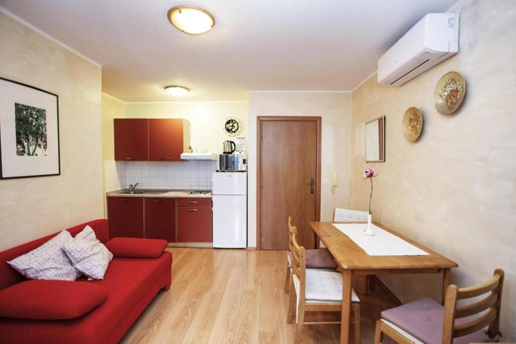 Dnevni boravak s crvenim kaučem i kuhinjom u apartmanu, Apartments Ulika Rovinj