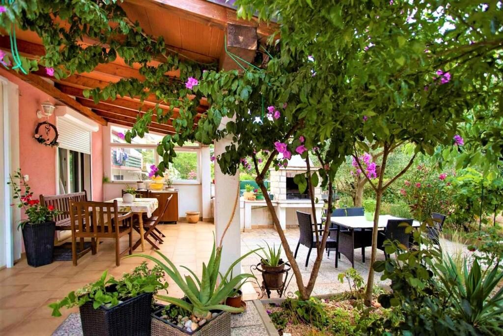 Natkrivena terasa s bugenvilijom i stolom za objedovanje u objektu Apartments Ulika, Rovinj